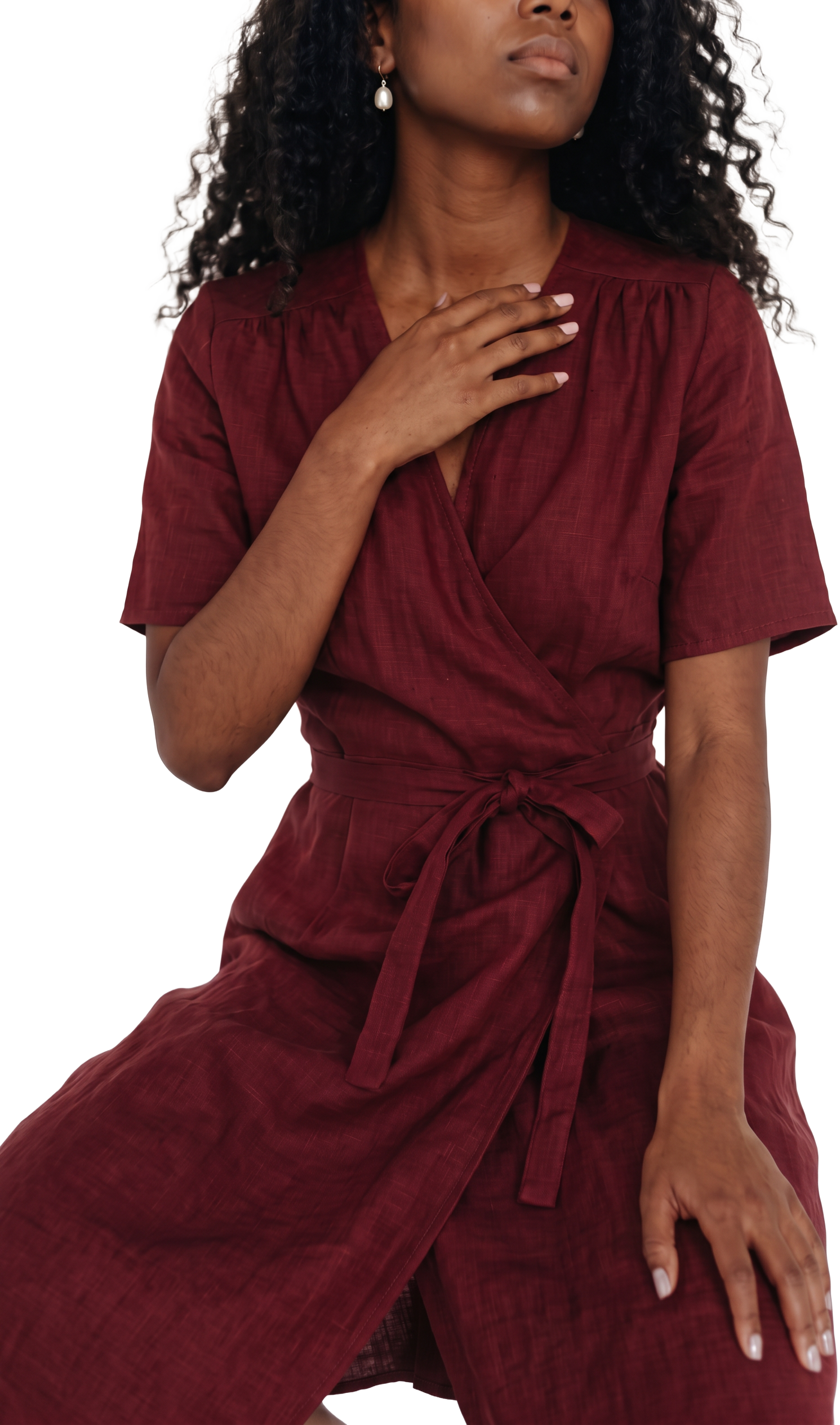 Black woman with curly hair in a burgundy linen wrap dress